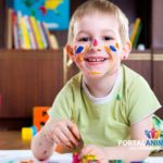 Cute little boy lying on floor and painting
