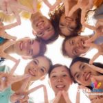group of smiling teenagers showing victory sign