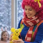 Animator dla dzieci przygotowuje balonowe zwierzątko podczas zimowych animacji dla najmłodszych