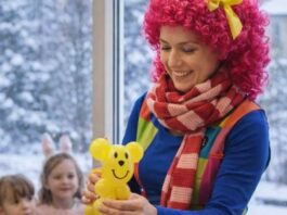 Animator dla dzieci przygotowuje balonowe zwierzątko podczas zimowych animacji dla najmłodszych