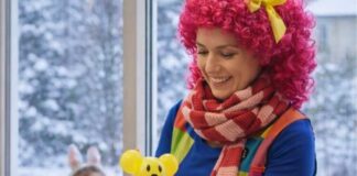 Animator dla dzieci przygotowuje balonowe zwierzątko podczas zimowych animacji dla najmłodszych