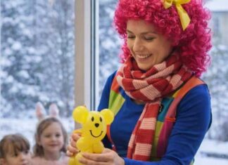 Animator dla dzieci przygotowuje balonowe zwierzątko podczas zimowych animacji dla najmłodszych