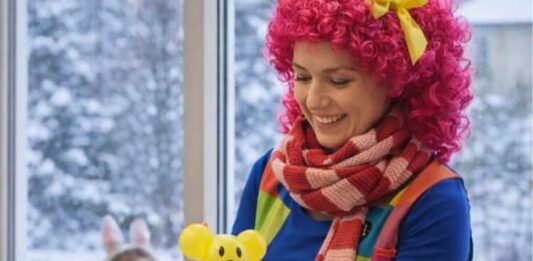 Animator dla dzieci przygotowuje balonowe zwierzątko podczas zimowych animacji dla najmłodszych
